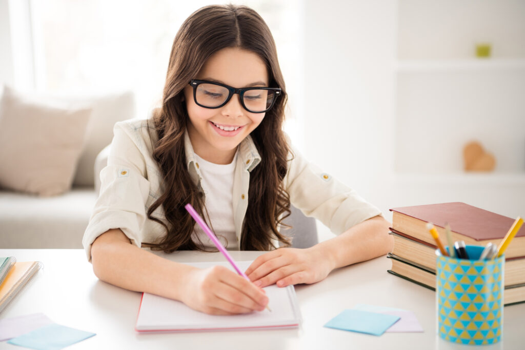 girl doing copywork at her desk during homeschool